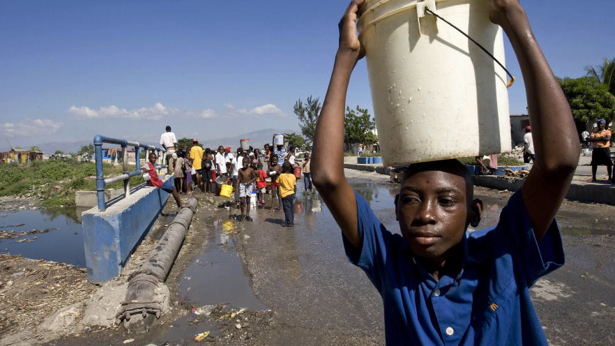 A boy in Cité Soleil carries away a hard-won bucket of water from a broken water pipe where many Haitians struggled for their share. The shanty town of Cité Soleil has been left with severely diminished water resources after a powerful earthquake rocked the area on 12 January.